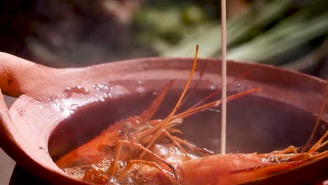 Sopa-De-Camarones-Humeante-Servida-En-Una-Olla-De-Barro-Tradicional,-Capturando-La-Esencia-De-La-Cocina-Tailandesa,-De-Cerca