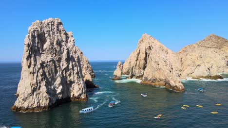 Kayaks-And-Boats-Sailing-By-El-Arco-At-Los-Cabos,-Cabo-San-Lucas,-Mexico-Aerial-View