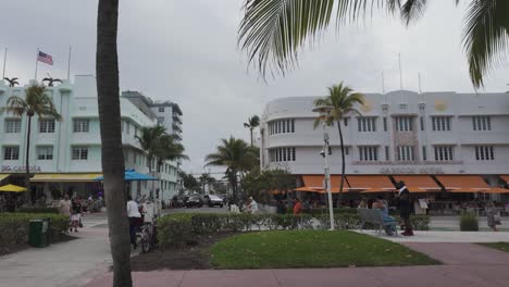 Menschen-Genießen-Einen-Bewölkten-Tag-In-Miami-Beach-Mit-Ikonischen-Art-Deco-Gebäuden-Und-Palmen