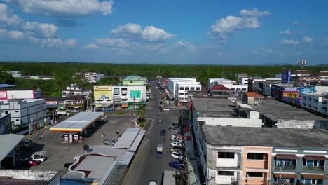 Amazing-aerial-view-flight-of-krabi-town-intersection-in-southern-thailand,-showing-a-mix-of-buildings,-a-river,-the-sea,-and-forested-hills-in-the-background