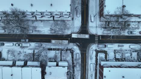 Aerial-rising-top-down-of-traffic-on-slushy-winter-road-in-housing-area