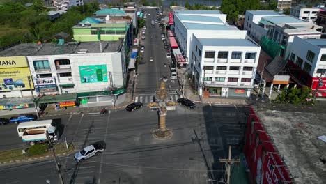 Atemberaubender-Luftbildflug-Einer-Straßenkreuzung-In-Der-Stadt-Krabi-Im-Süden-Thailands,-Der-Eine-Mischung-Aus-Gebäuden,-Einem-Fluss,-Dem-Meer-Und-Bewaldeten-Hügeln-Im-Hintergrund-Zeigt