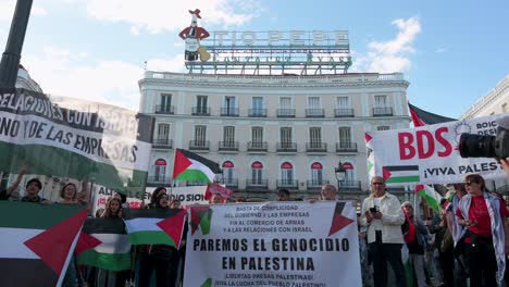 Bei-Der-Demonstration-Halten-Pro-palästinensische-Demonstranten-Palästinensische-Flaggen-Und-Ein-Plakat-Hoch,-Auf-Dem-Sie-Ein-Ende-Der-Waffenverkäufe-An-Israel-Fordern-Und-Gleichzeitig-Dafür-Eintreten,-Den-Völkermord-In-Palästina-Zu-Beenden.