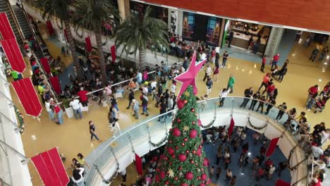 Aumento-Aéreo-De-Multitud-En-El-Centro-Comercial-La-Vela-Isla-De-Margarita-Durante-La-Temporada-Navideña-Reunidos-Alrededor-Del-árbol-De-Navidad