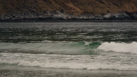 Ocean-waves-reaching-sandy-beach-in-Norway,-follow-view