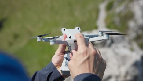 A-person-holding-a-small-drone-removes-and-inserts-a-fresh-lithium-battery