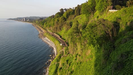 drone-shoot-of-Black-sea-Batumi-coast-beautiful-nature-railway-mountains-nature-side-of-Batumi-beach-sunset