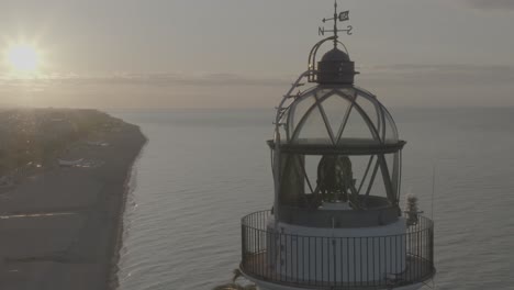 Reveling-shot-of-Calella-city-while-being-close-to-a-lighthouse,-located-in-Calella,-Catalunya,-Spain,-shot-in-Dlog