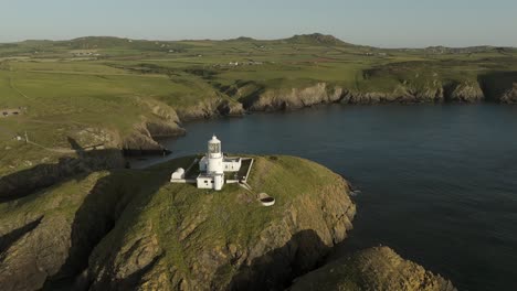 An-aerial-view-of-the-of-Strumble-Head-lighthouse-in-Pembrokeshire,-South-Wales,-on-a-sunny-summer-evening