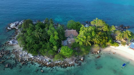 Nice-aerial-view-flight-of-a-Hut-on-a-tropical-Sole-peninsula-with-turquoise-water-and-lush-green-vegetation