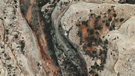 Aeiral-drone-down-angle-of-snaking-riverbed-in-rocky-Utah-landscape