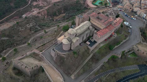 Cardona-castle-and-the-surrounding-town-in-a-rugged-landscape,-aerial-view