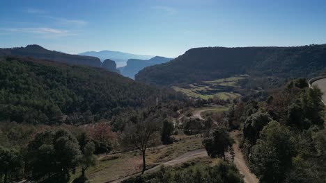 Scenic-view-of-the-Tavertet-region-with-lush-greenery-and-distant-mountains-under-a-clear-blue-sky