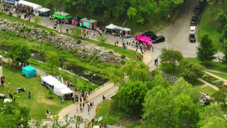 People-And-Booths-On-Street-Near-Sager-Creek-During-50th-Dogwood-Festival-In-Siloam-Springs,-Arkansas