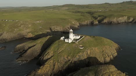 An-aerial-view-of-the-of-Strumble-Head-lighthouse-in-Pembrokeshire,-South-Wales,-on-a-sunny-summer-evening