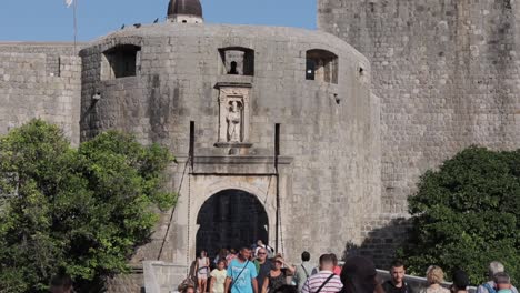 People-walking-in-old-historic-houses,-Main-entrance-to-Dubrovnik-old-town,-Croatia