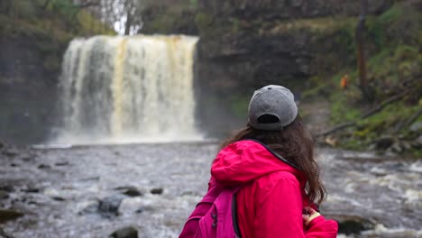 Hiker-with-hat-posing-in-front-of-Sgwd-Yr-Eira-Waterfall-in-Wales