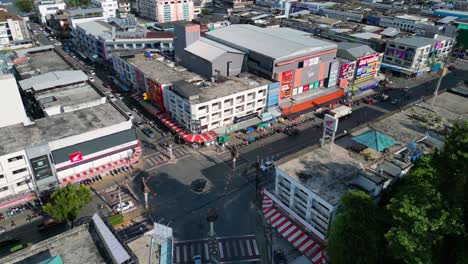 Marvelous-aerial-view-flight-of-intersection-krabi-town-in-southern-thailand,-showing-a-mix-of-buildings,-a-river,-the-sea,-and-forested-hills-in-the-background