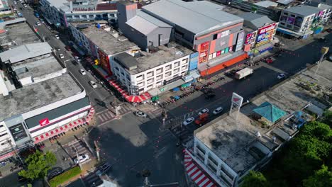 Wonderful-aerial-view-flight-of-intersection-krabi-town-in-southern-thailand,-showing-a-mix-of-buildings,-a-river,-the-sea,-and-forested-hills-in-the-background