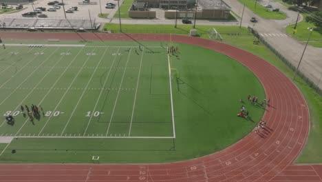 An-aerial-drone-view-of-Clear-Lake-High-School-students-participating-in-summer-football-camp-at-CLHS-in-Clear-Lake,-Houston,-Texas