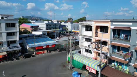 Perfect-aerial-view-flight-of-krabi-town-in-southern-thailand,-showing-a-mix-of-buildings,-a-river,-the-sea,-and-forested-hills-in-the-background