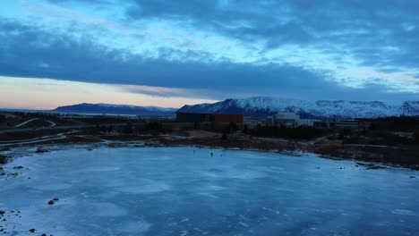 Aerial-travelling-shot-over-frozen-lake-Raudavatn,-near-Reykjavík,-Iceland