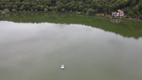 Vista-Aérea-Del-Lago-Rodeado-De-Montañas-Bosques-De-árboles-Verdes