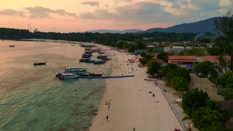 Sun-setting-over-a-stunning-thai-beach,-tourists-soaking-in-the-view