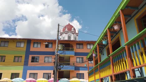 Colorful-buildings-in-Guatapé,-Colombia,-with-umbrellas-and-vibrant-facades