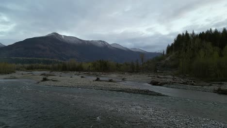 River,-Shore-with-Trees-and-Mountains-at-Sunset