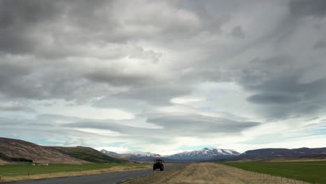 Tractor-driving-on-road-in-scenic-landscape-of-Icleand-during-cloudy-day