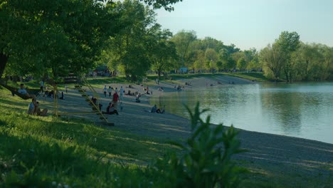 Menschen-Entspannen-Am-Strand-Und-Genießen-Die-Ruhige-Atmosphäre-Am-Jarun-See-In-Zagreb,-Kroatien