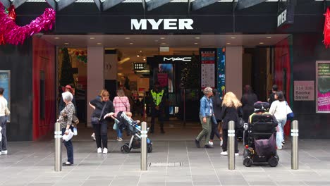 Myer's-flagship-store-on-Melbourne's-Bourke-Street-Mall-with-pedestrians-strolling-by,-showcasing-the-bustling-shopping-hub,-captured-in-slow-motion