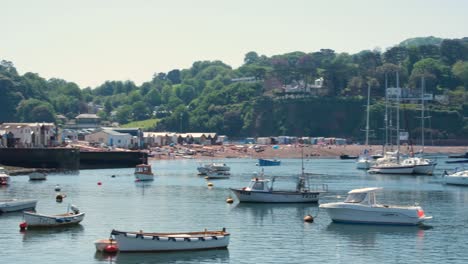 Scenic-view-of-Teignmouth-busy-beach-packed-with-people-and-harbour-and-boats-in-popular-seaside-holiday-destination-in-Devon,-England-UK