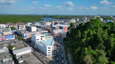 Vista-Aérea-De-La-Ciudad-De-Krabi,-En-El-Sur-De-Tailandia,-Que-Muestra-Una-Mezcla-De-Edificios,-Un-Río,-El-Mar-Y-Colinas-Boscosas-Al-Fondo.