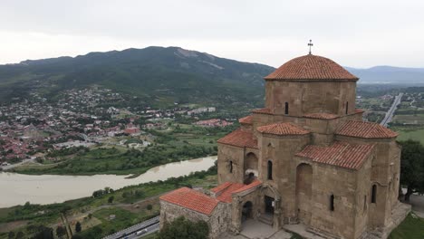 Aerial-shot-of-Jvari-church-Mtskheta-Georgia-river-city-mountains-meadows-forest