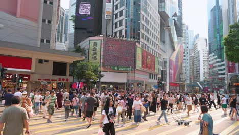 Pedestrians-walk-through-a-busy-and-crowded-zebra-crossing-in-the-retail-district-of-Wan-Chai,-Hong-Kong