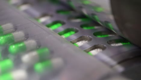 close-up-seen-which-packing-green-and-white-painkiller-capsule-is-being-packed,-safety-first-concept