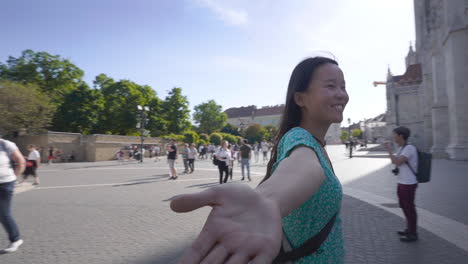 Alegre-Mujer-Asiática-Sonriendo-Mientras-Camina-Con-Los-Brazos-Abiertos-En-El-Bastión-De-Los-Pescadores-En-Budapest,-Hungría