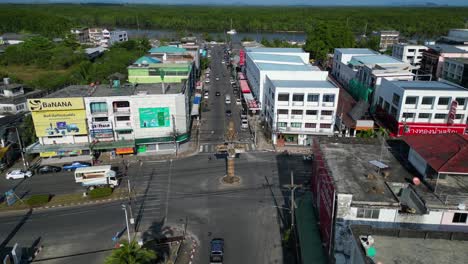 Perfect-aerial-view-flight-of-krabi-town-intersection-in-southern-thailand,-showing-a-mix-of-buildings,-a-river,-the-sea,-and-forested-hills-in-the-background