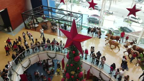 Aerial-orbits-of-crowds-in-La-Vela-shopping-mall,-Isla-de-Margarita,-during-festive-winter-season