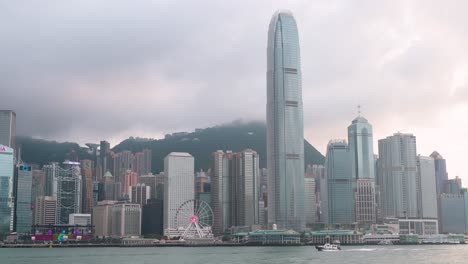 Schwenkaufnahme-Der-Uferpromenade-Von-Victoria-Harbour-Mit-Der-Skyline-Und-Den-Wolkenkratzern-Von-Hong-Kong-Island