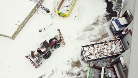 Tractor-Scraping-Snow-At-Warehouse-Dock-In-Early-Spring-In-Montreal,-Canada