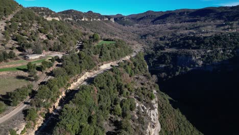 A-winding-road-in-the-mountainous-tavertet-region-near-barcelona,-aerial-view