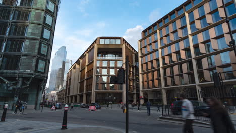 Wide-angle-time-lapse-of-busy-road-in-London-leading-to-Bank,-with-beautiful-drifting-clouds-reflections-on-the-buildings