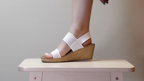 Woman-wears-cork-and-white-platform-sandal-heels-posing-for-summer-tapping-her-foot