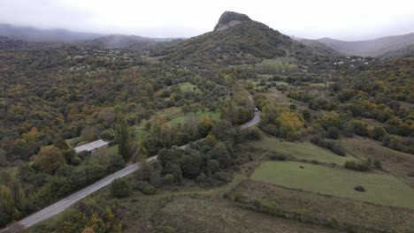 Aerial-view-of-mountains-village-country-road-in-beautiful-green-meadows-mountains