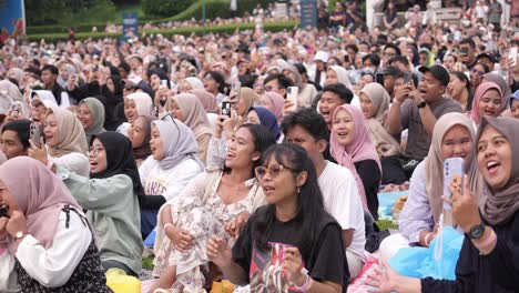 Indonesian-People-and-Women-With-Hijab-Gathered-Seated-and-Singing-At-Outdoor-Music-Concert