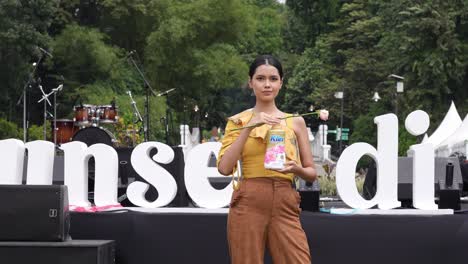 Una-Modelo-Indonesia-Muestra-Un-Producto-Al-Aire-Libre