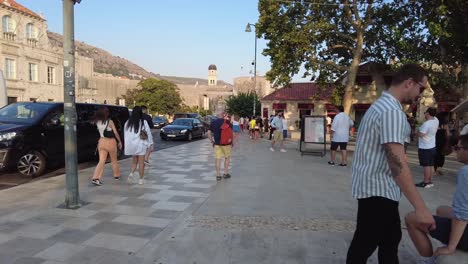 Tourists-stroll-through-a-bustling-square-in-Dubrovnik,-Croatia-during-a-sunny-afternoon